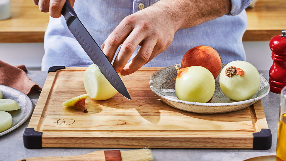 Onion being chopped on a cutting board.