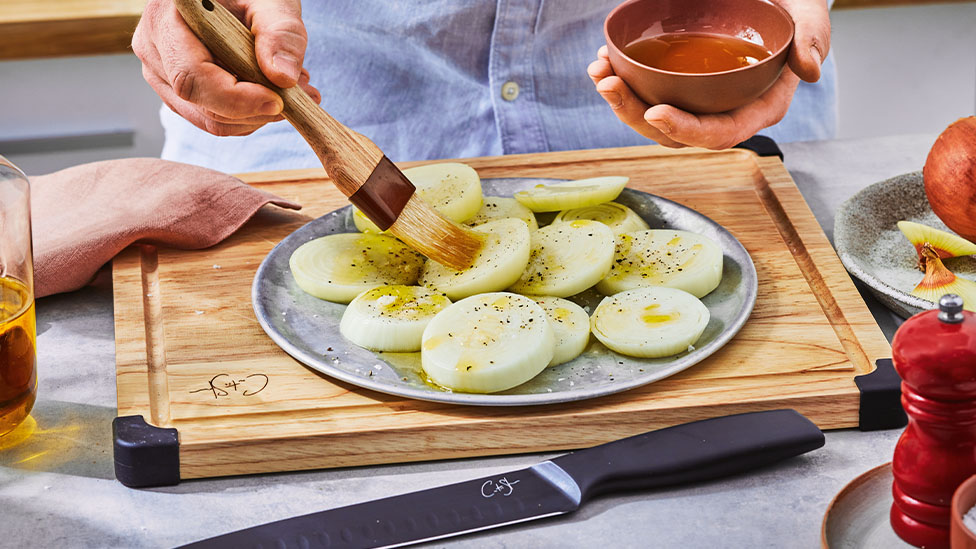Onion being brushed with oil.
