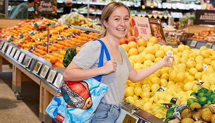 A lady purchasing a bag of lemons