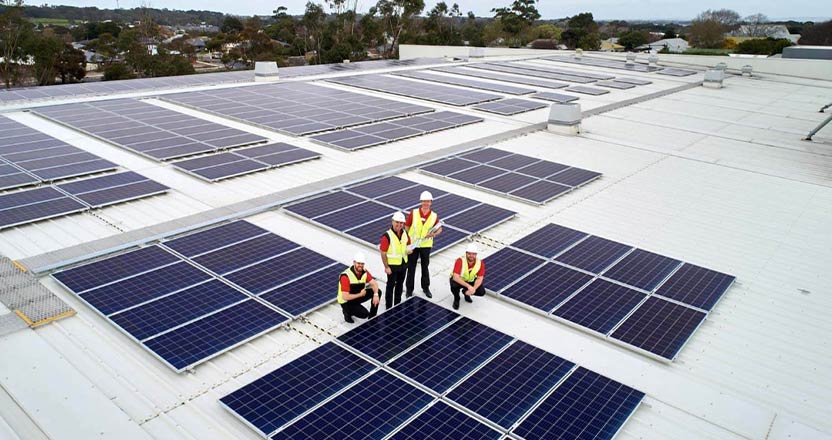 Four engineers surrounded by solar panels