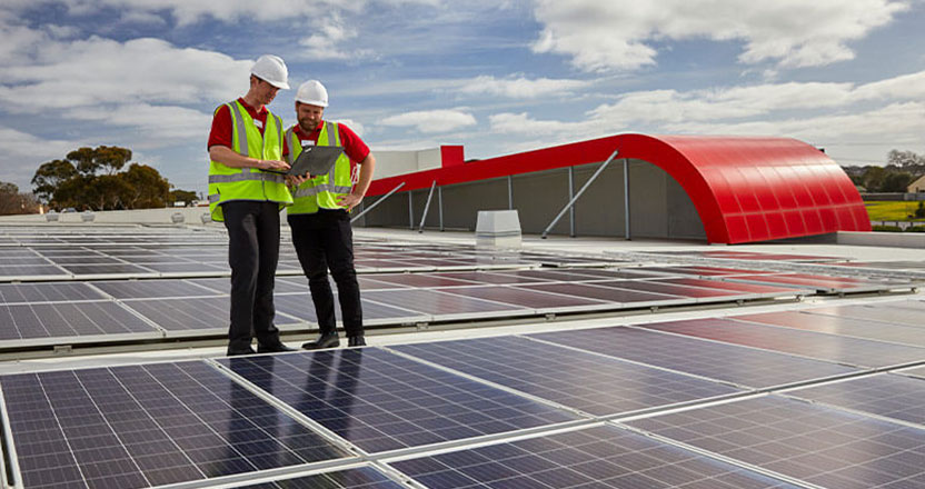 Coles team members inspect solar panels on roof of Coles' supermarket at Drysdale, Victoria