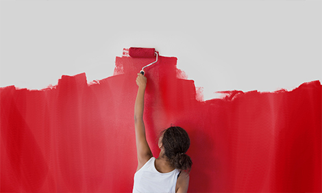 A woman painting the wall red