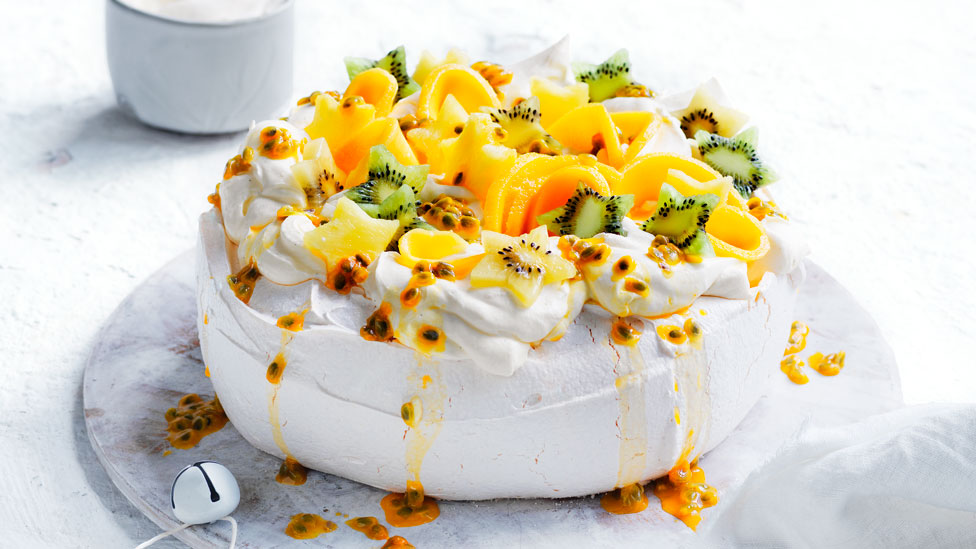 A traditional pavlova with passion fruit and kiwifruit on top