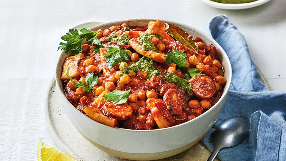 Braised squid with chorizo and mojo sauce served in a bowl with parsley on top