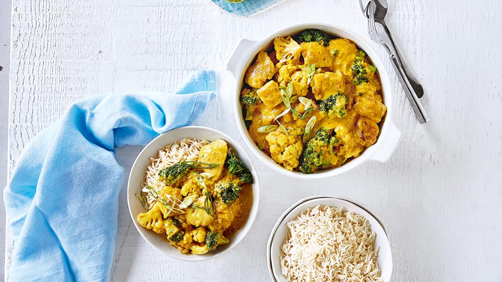 Two bowls of chicken satay with a bowl of coconut rice