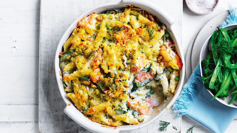 Baking dish of salmon pasta bake with a scoop taken out