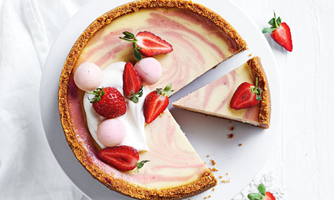 A strawberries and cream baked cheesecake with fresh strawberries on top
