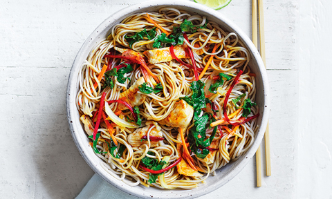 Japanese style pork and soba noodle stir-fry with chop sticks and a lime wedge on the side
