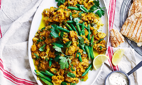 A dish of roasted cauliflower dahl with broccoli on the top