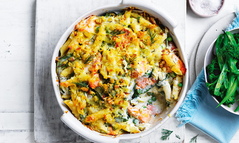 Baking dish of salmon pasta bake with a scoop taken out