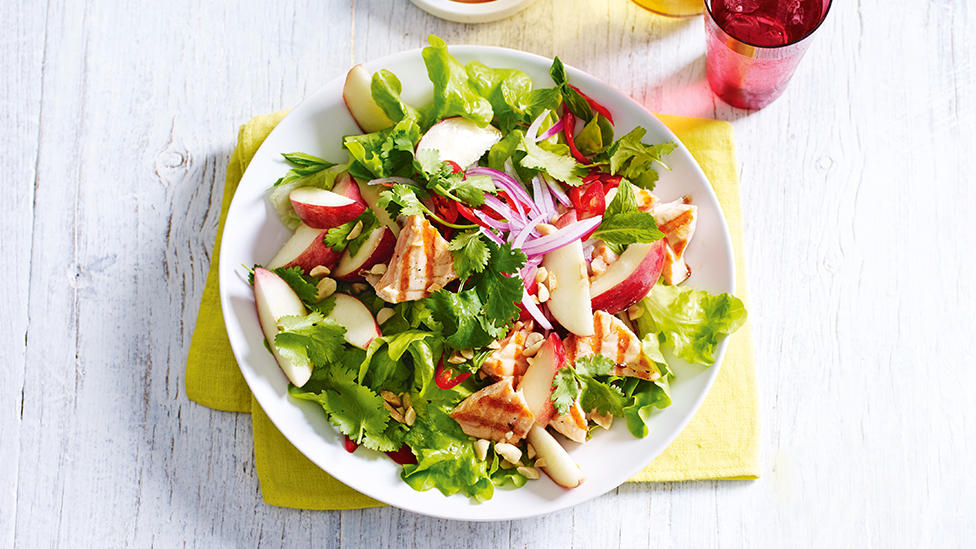 Salad of salmon, white peach and lettuce in a bowl