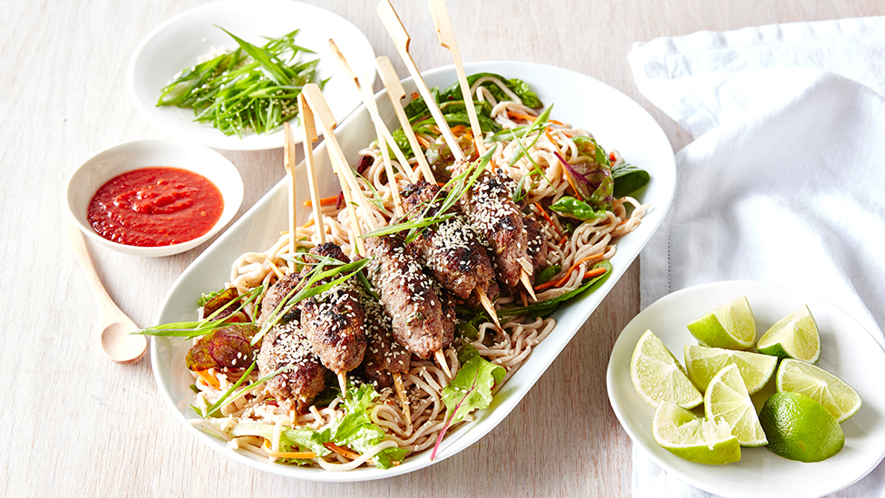 Asian-style beef kebabs on a noodle salad