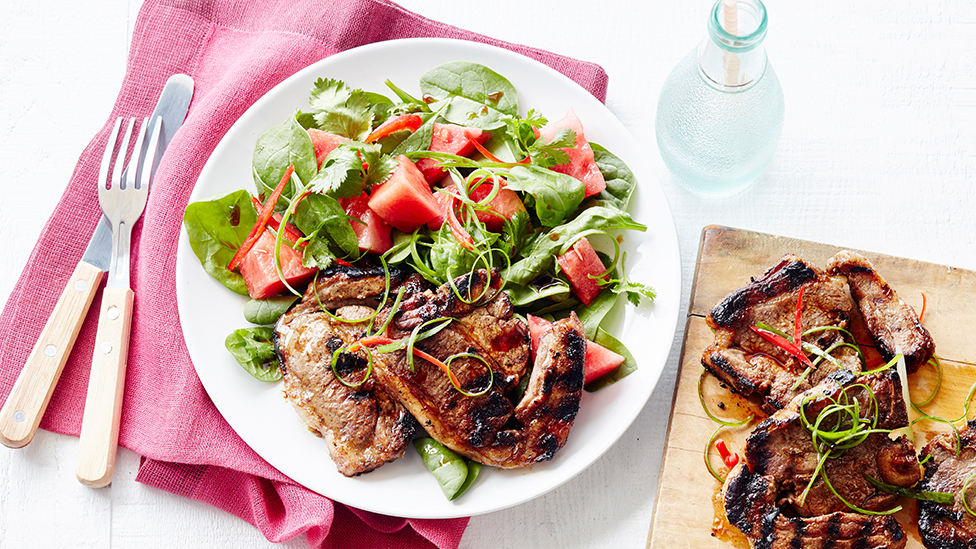 Marinated lamb chops with a spinach and watermelon salad on a plate