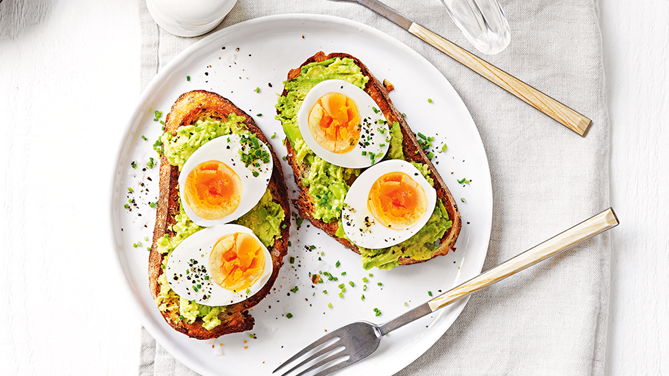 Smashed avocado with sliced egg on toast