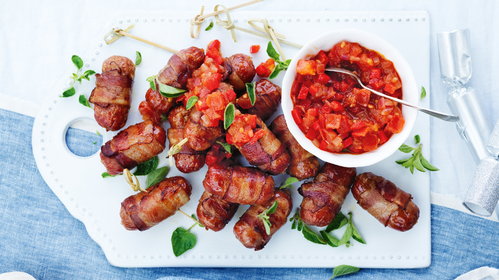 Bacon-wrapped beef sausages with tomato salsa