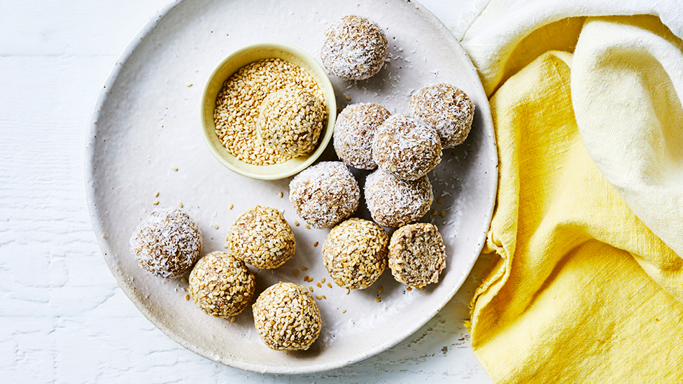 banana bliss balls rolled in sesame seeds or dessicated coconut on a plate