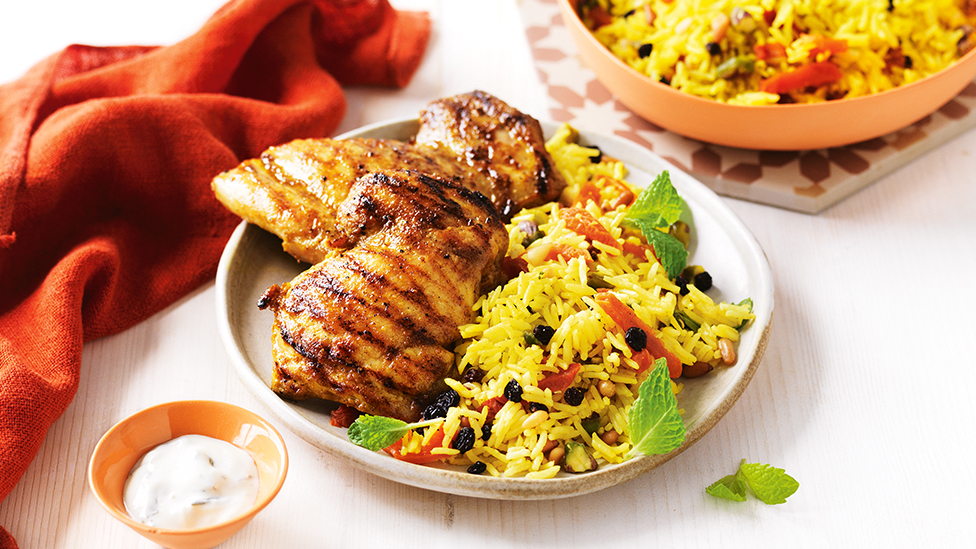 Barbecued chicken thighs served with a Persian rice salad