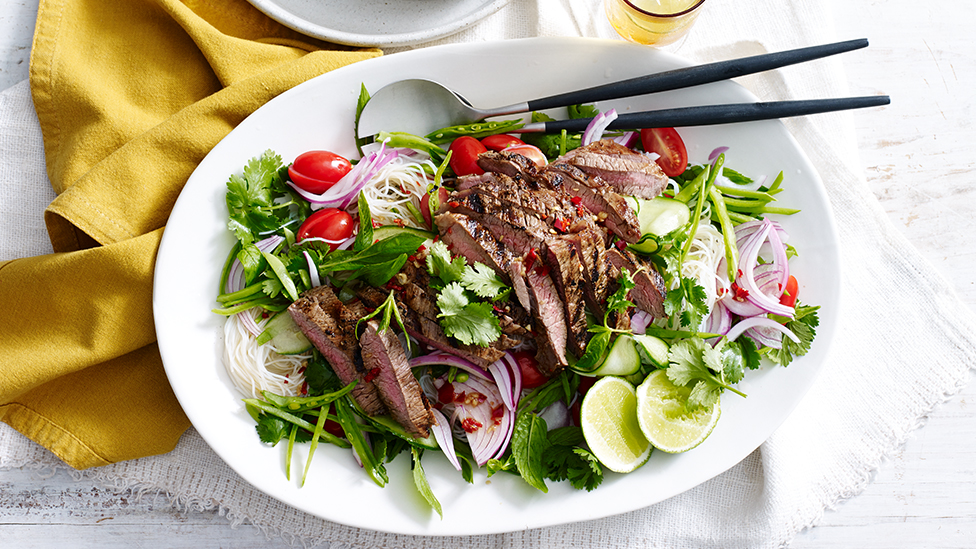 A vermicelli noodle salad topped with sliced steak