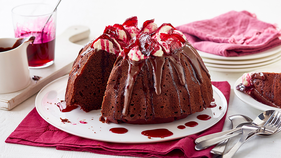 Beetroot and chocolate cake on a serving plate with a slice cut and in a bowl