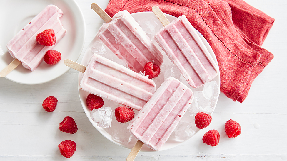 Beetroot and raspberry ice blocks resting on a bowl of ice