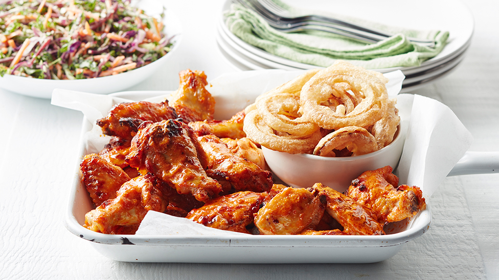 Buffalo wings with crispy onion rings and kale slaw