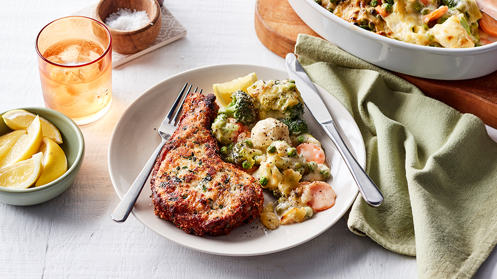Crumbed pork chop with cheesy vegetables