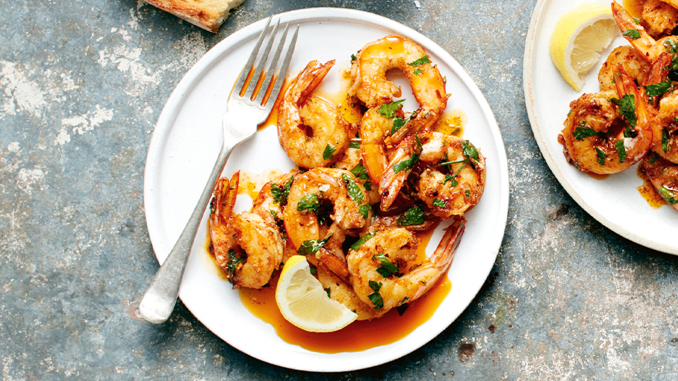 Garlic prawns on a plate served with a wedge of lemon