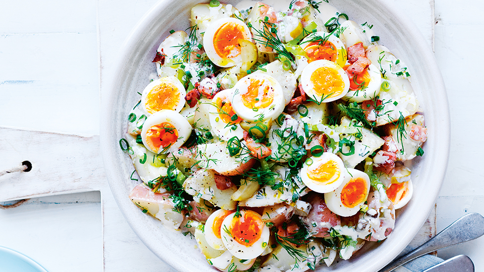 German-style potato salad in a bowl topped with sliced boiled eggs