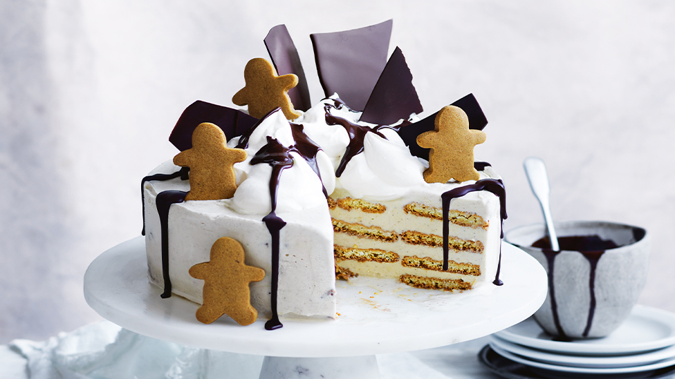 Gingerbread ice cream cake on a plate with a slice missing