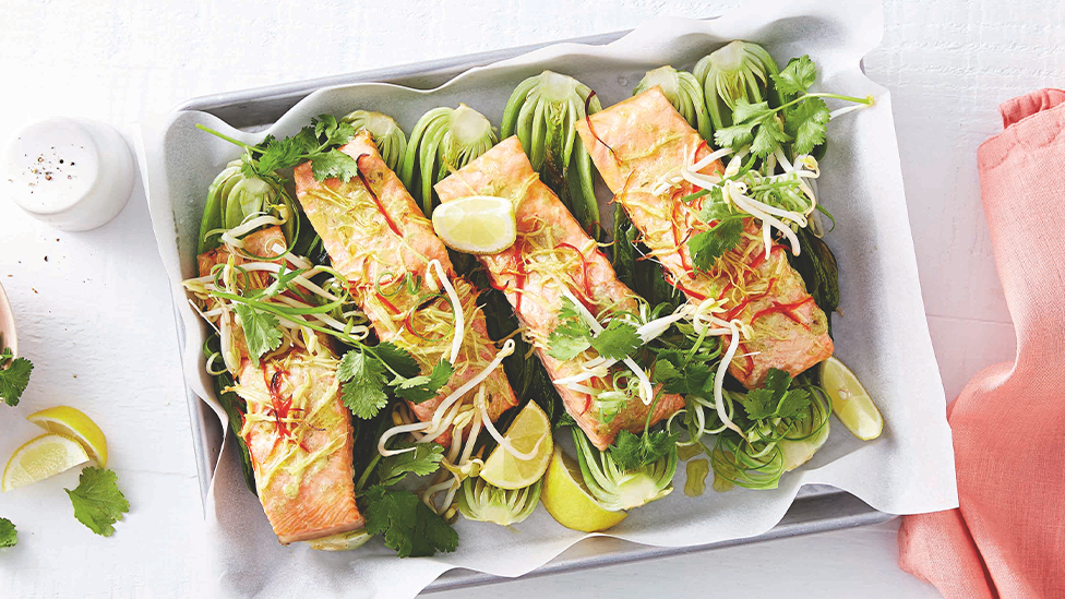 Salmon fillets on a bed of pak choy sprinkled with sliced coriander and bean sprouts