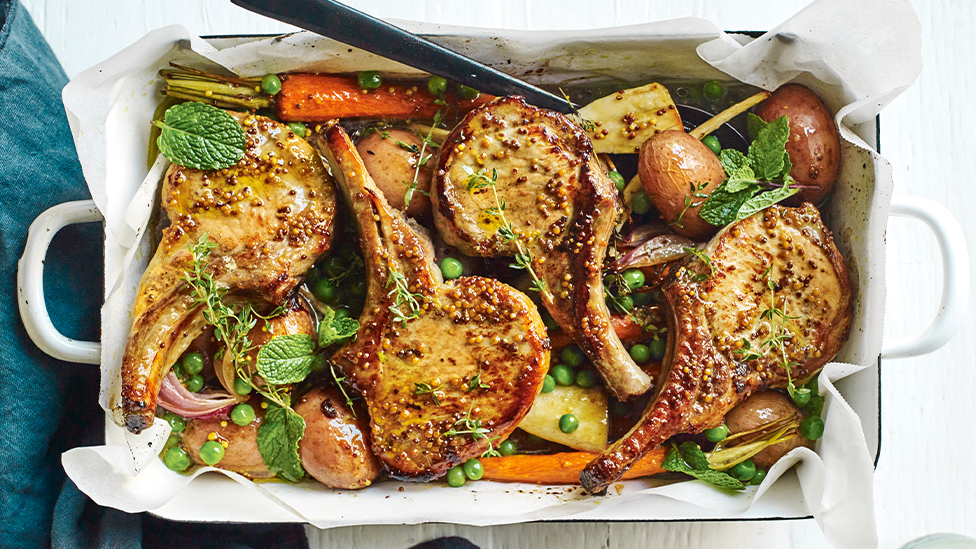 Tray bake of potato, parsnip, carrots, peas and pork cutlets