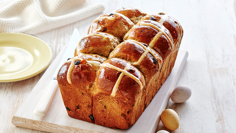 Loaf of banana flavoured hot cross buns on a board