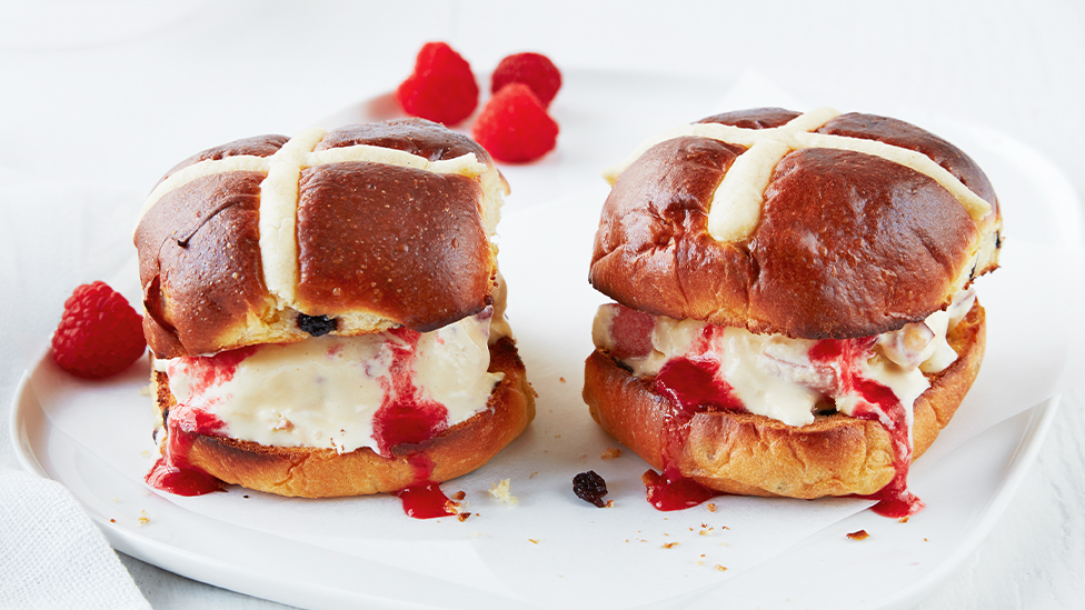 Two hot cross bun and frozen custard sandwiches on a plate