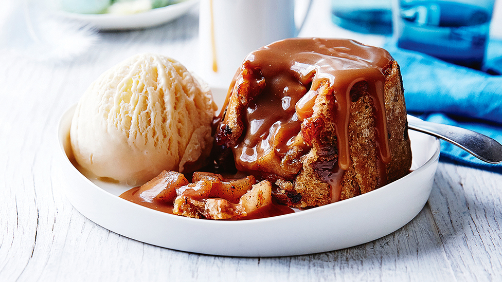 Hot cross bun apple and pear charlotte dessert in a shallow bowl with a scoop of vanilla ice-cream