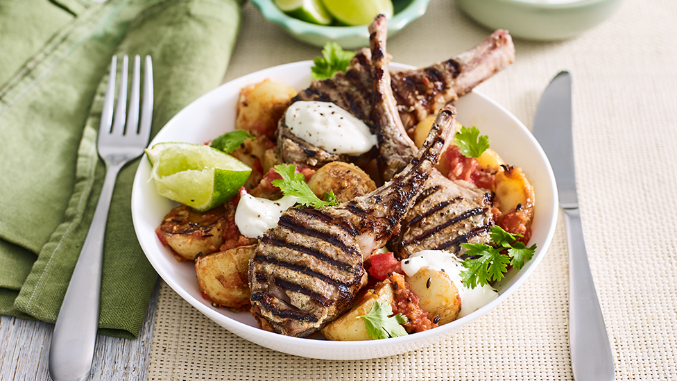 Indian-spiced barbecued lamb cutlets in bowl with Bombay potatoes