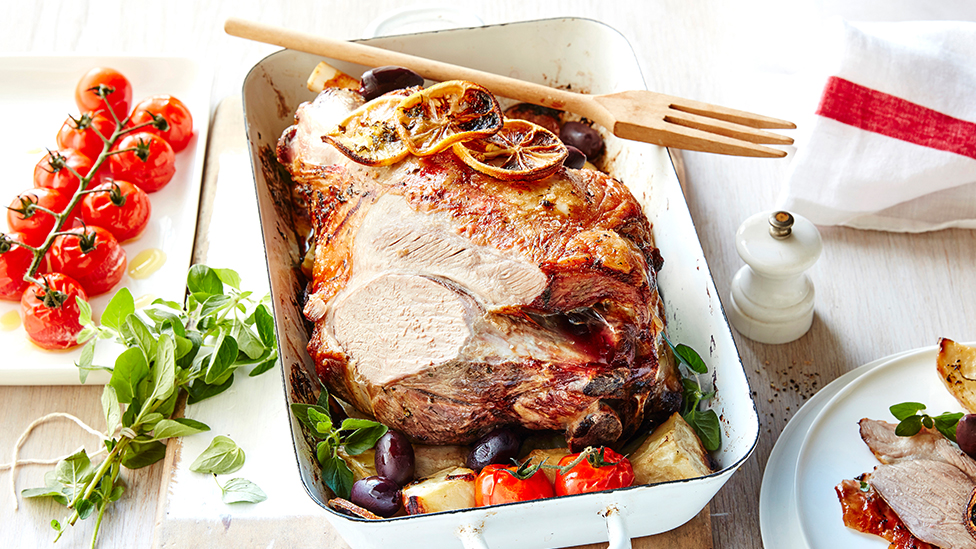 Roast lamb with lemon-oregano potatoes and roast tomatoes