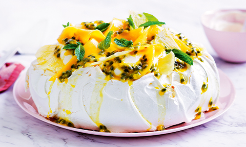 Pavlova topped with cream and fruit