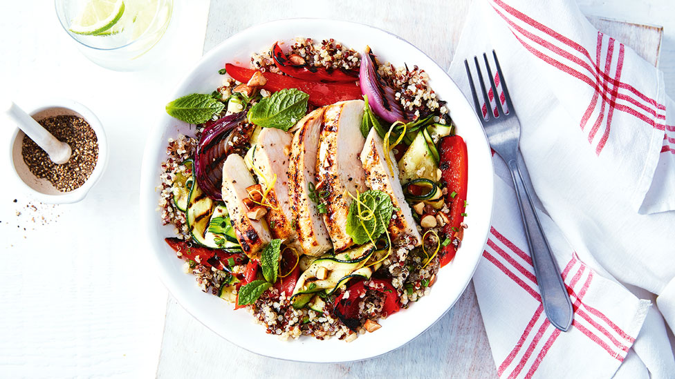 One serve of chicken quinoa salad, garnished with mint leaves.