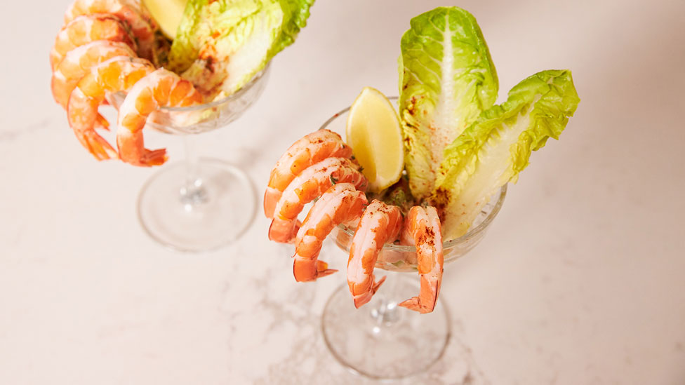 Two glasses of prawn cocktails with avocado and dill