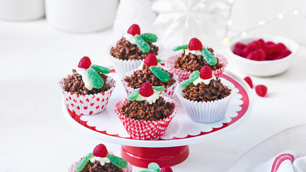 Six chocolate crackle puddings decorated with raspberries and mint leaf lollies