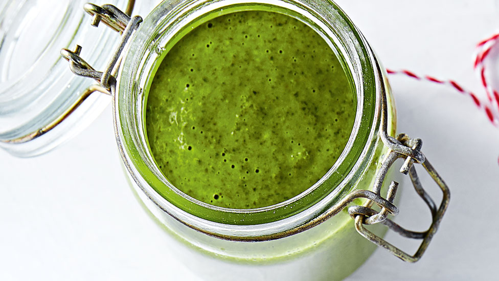 Vibrant green jalapeño chimichurri in a glass jar.