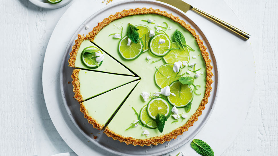 Margarita cheesecake tart topped with lime sices and mint leaves