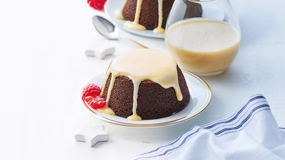 A mini chocolate Christmas pudding drizzled with caramel sauce