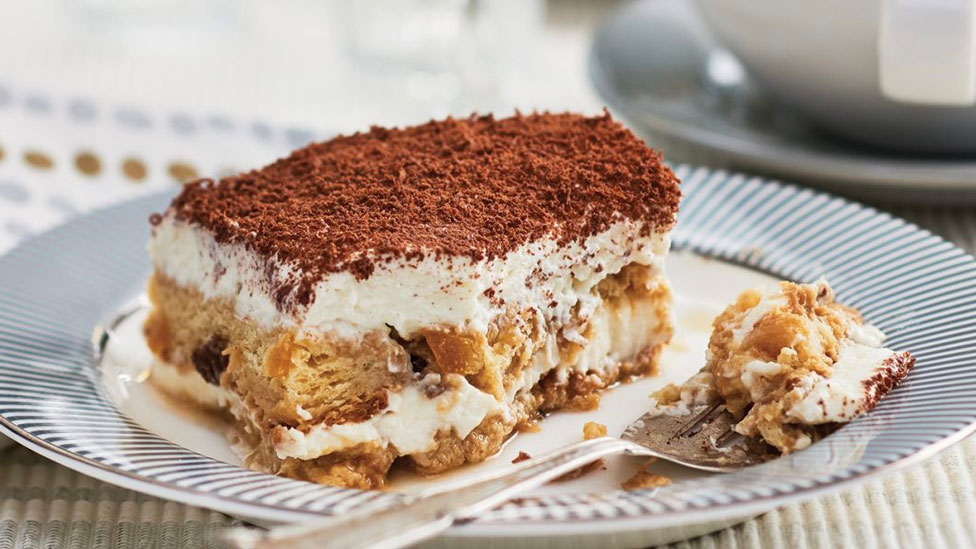 A slice of panettone tiramisu dusted with coco powder