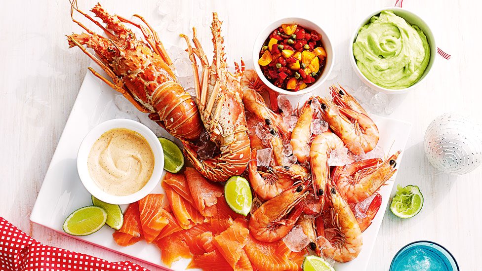 A platter of seafood with prawns, lobster, salmon and lime