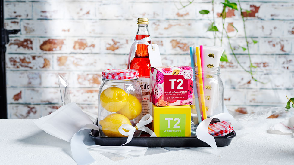 A hamper for drinks consisting with mixers, lemons and some decorations