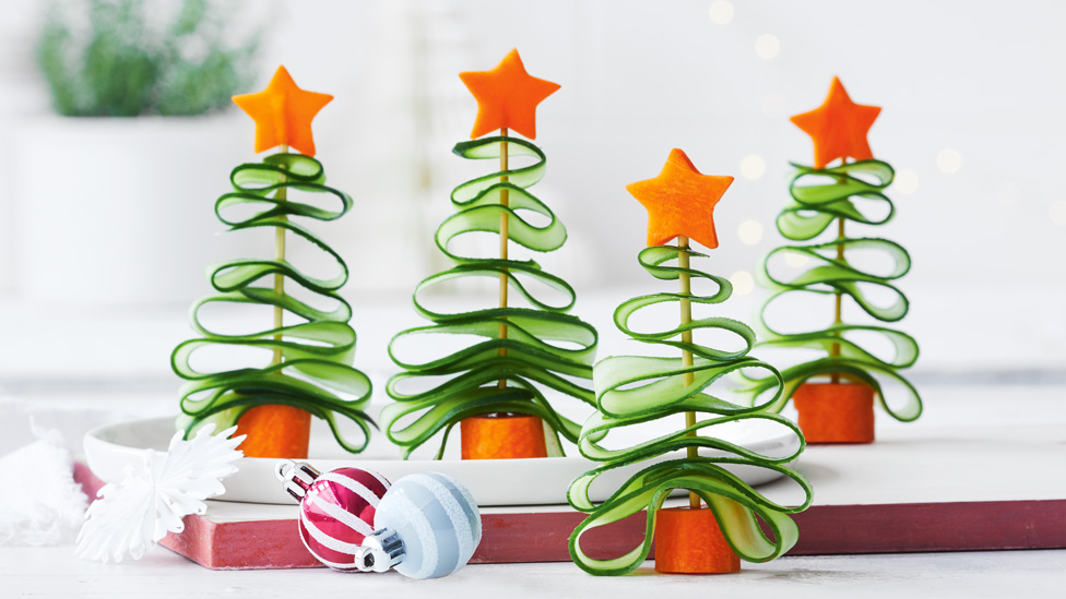 Four veggie Christmas trees made of carrots and cucumber slices