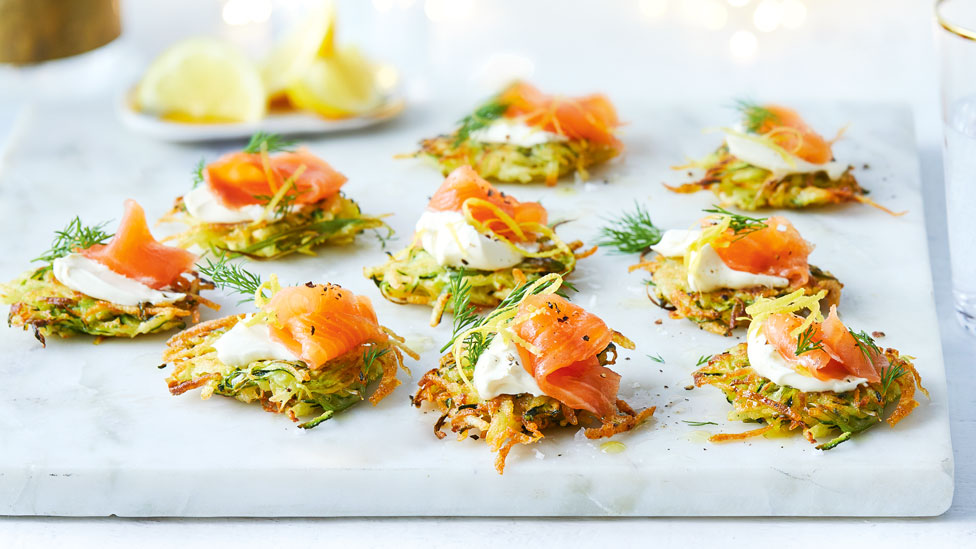 Nine zucchini fritters with cold-smoked salmon, served with lemon wedges