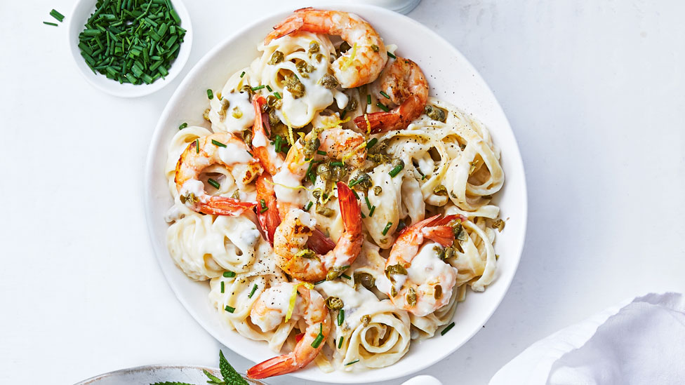 Creamy linguine carbonara with prawns and baby capers, with chopped chives on the side. 