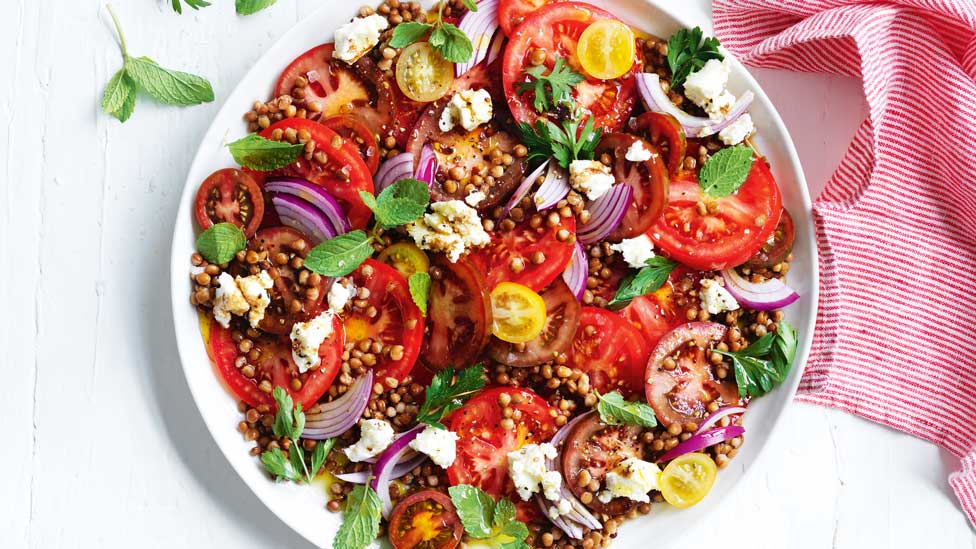 Mixed tomato salad with lentils on a serving platter